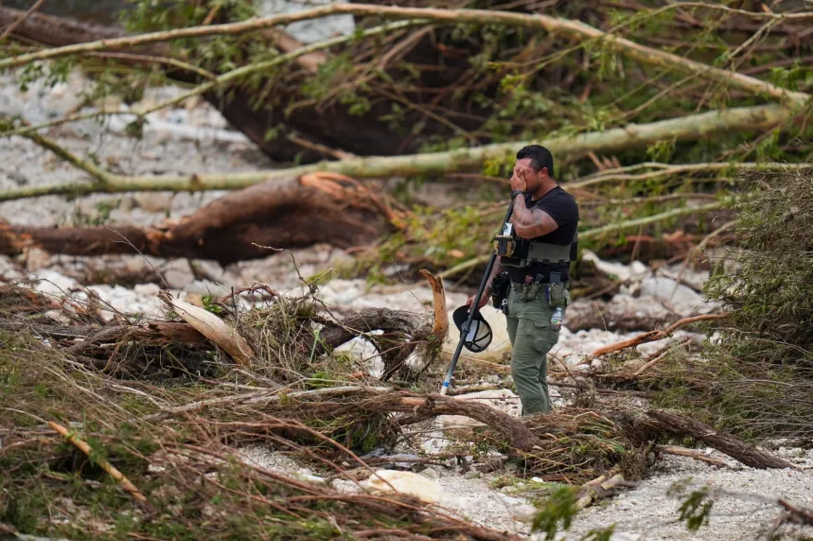 Un agente del Sheriff se detiene mientras peina las orillas del río Guadalupe cerca de Camp Mystic. Julio Cortez/AP